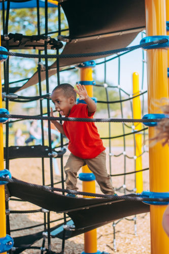 boy on Roane playground equipment